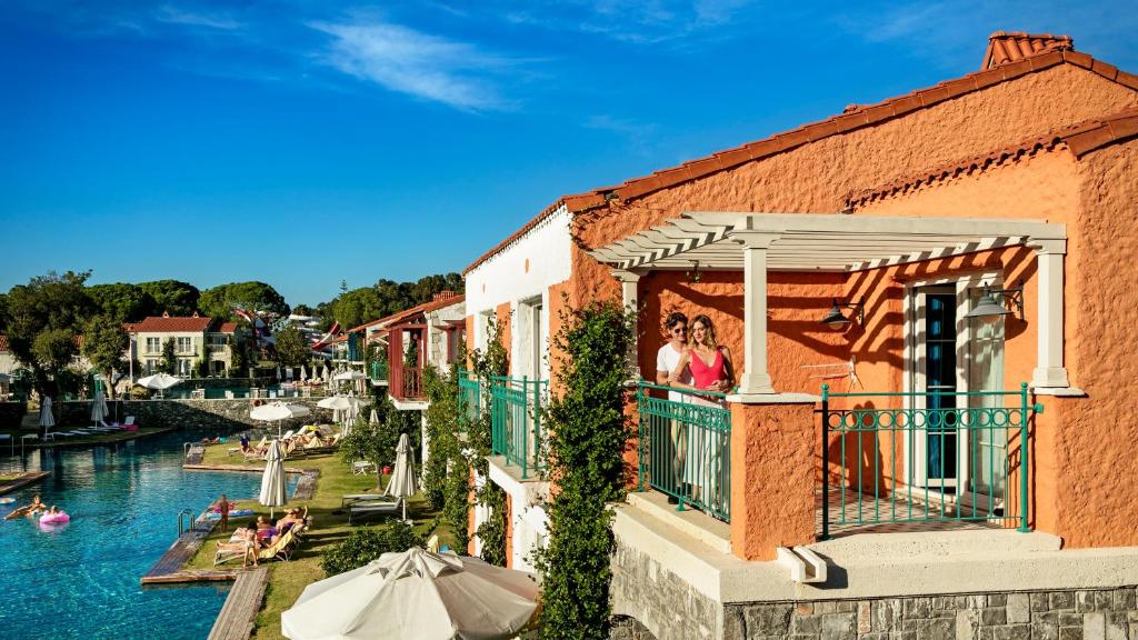 a woman on a balcony looking out at the water at IC Hotels Santai Family Resort - Kids Concept in Belek