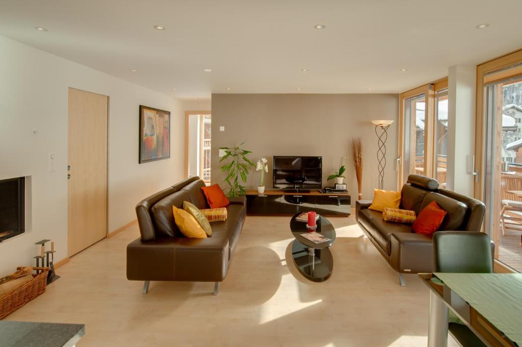 a living room with two couches and a television at Apartment Meric Superior in Zermatt