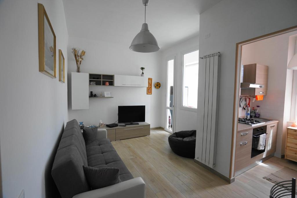uma sala de estar com um sofá e uma televisão em Moralma em Sarzana