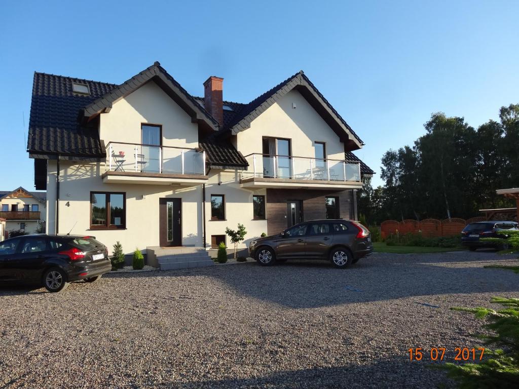 una casa con dos coches aparcados en una entrada en Villa Cork, en Dębki