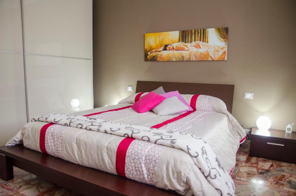 a large bed with white sheets and pink pillows at B&B Marialdo in Bussoleno