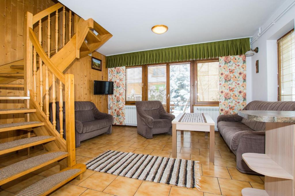 - un salon avec un escalier et un canapé dans l'établissement Apartamenty U Zajaców, à Zakopane