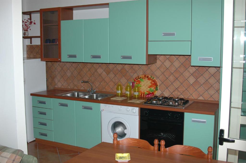 kuchnia z niebieskimi szafkami i pralką w obiekcie Villa Catalano w mieście Paola