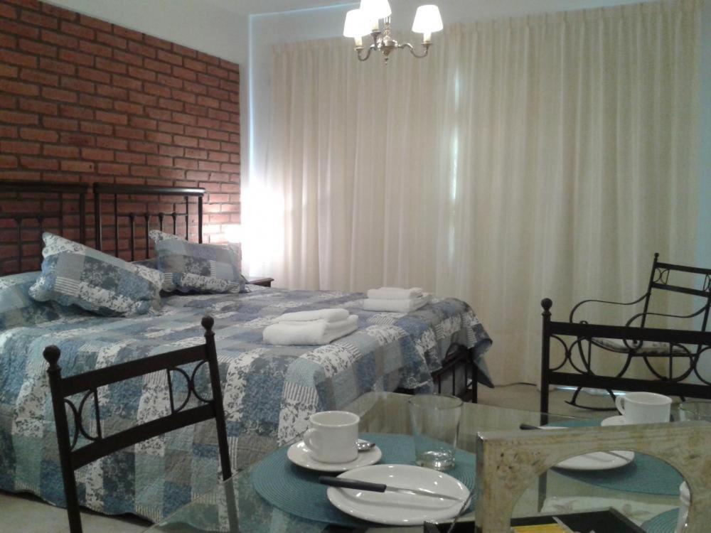 1 dormitorio con 1 cama y 1 mesa con 2 sillas en La Linda Apart en Salta