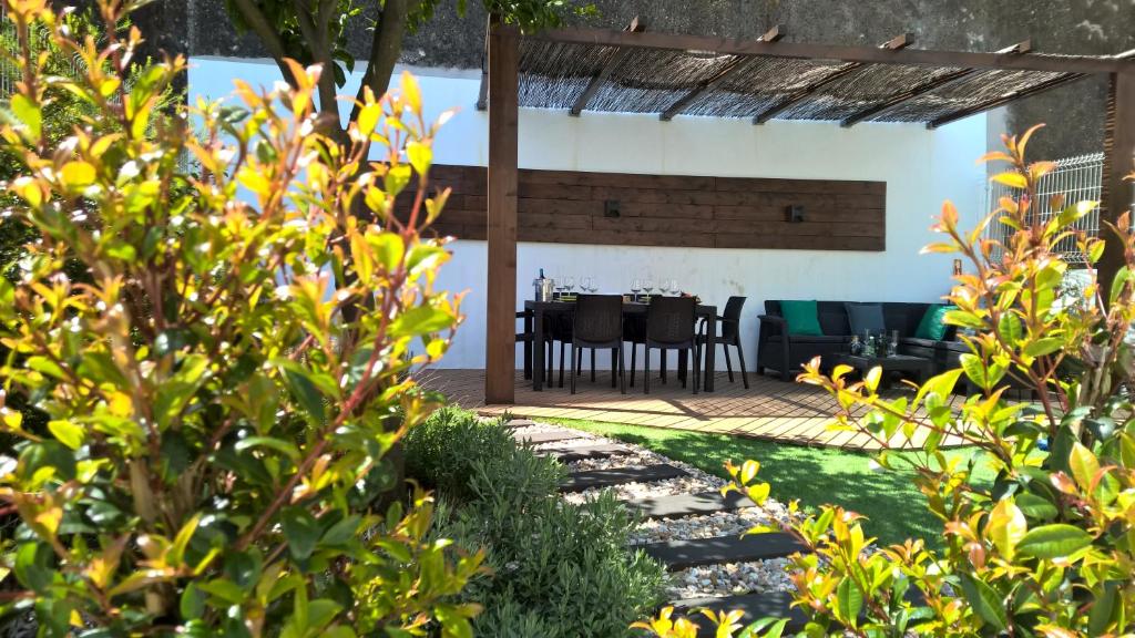 een tuin met een tafel en stoelen op de achtergrond bij Graça Garden Home in Lissabon