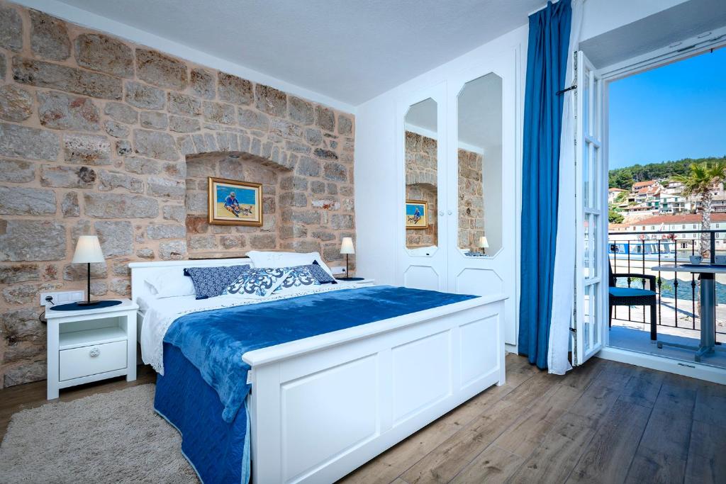 a bedroom with a bed and a brick wall at Villa Riva in Jelsa