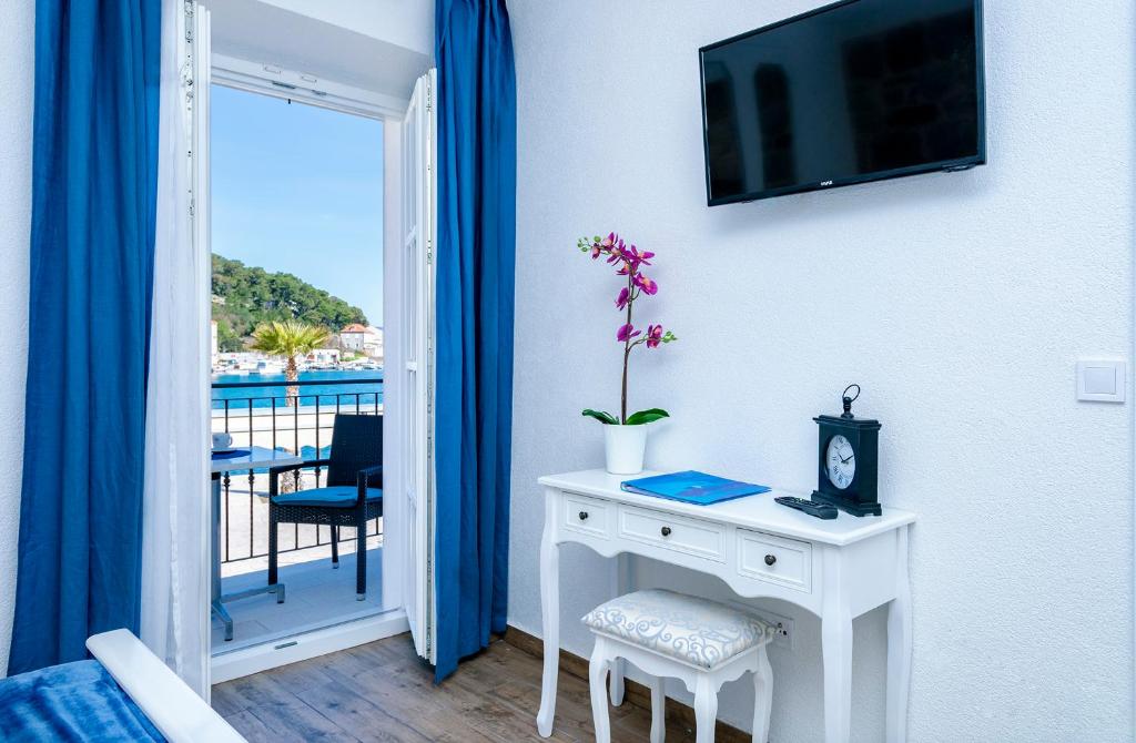 a room with a white table and a tv on a wall at Villa Riva in Jelsa
