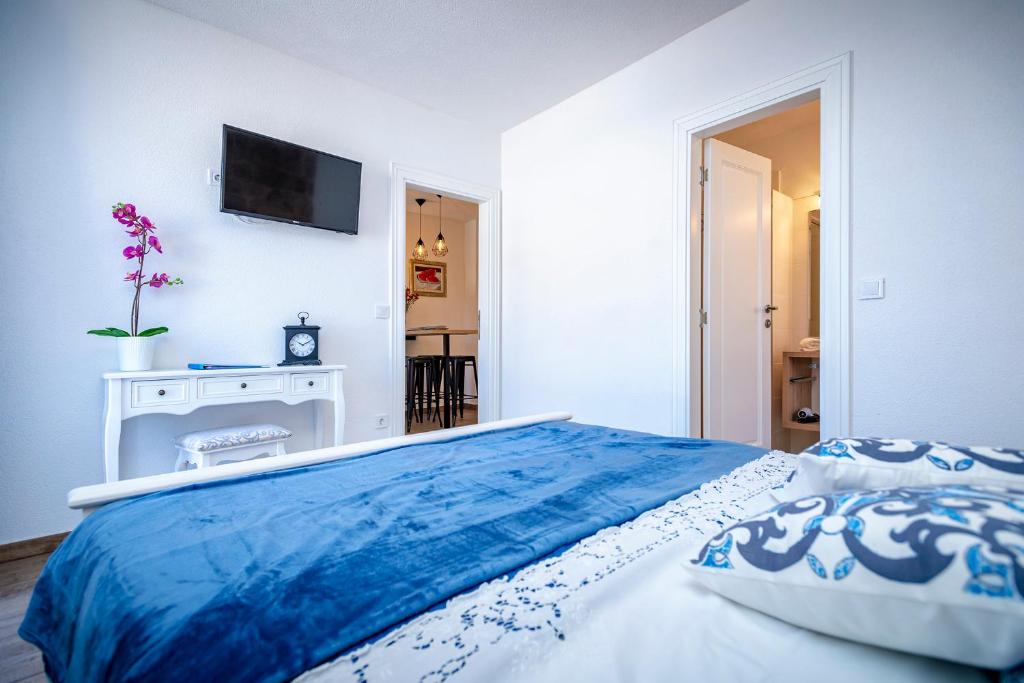 a bedroom with a bed with a blue blanket on it at Villa Riva in Jelsa