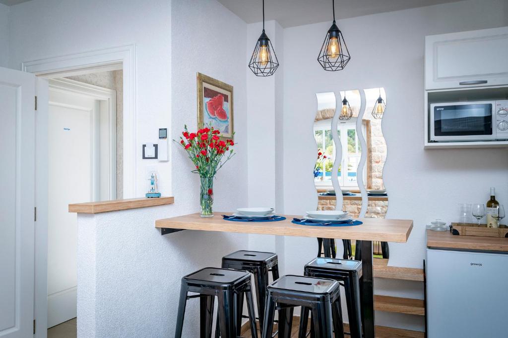 a kitchen with a counter with stools and a table at Villa Riva in Jelsa