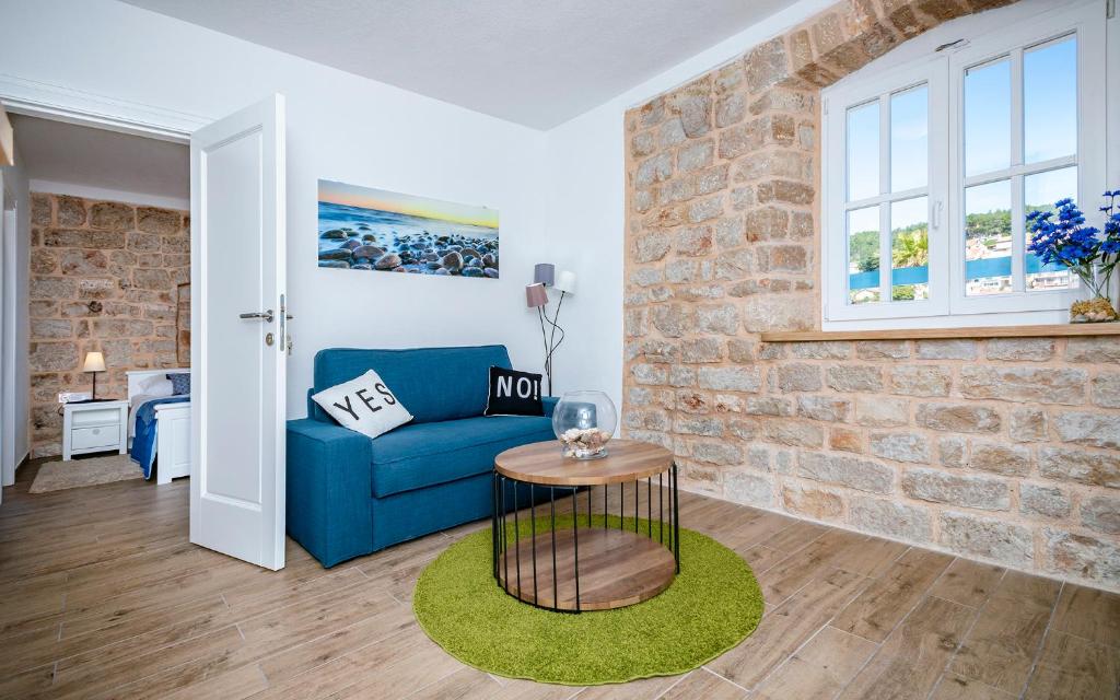 a living room with a blue couch and a brick wall at Villa Riva in Jelsa