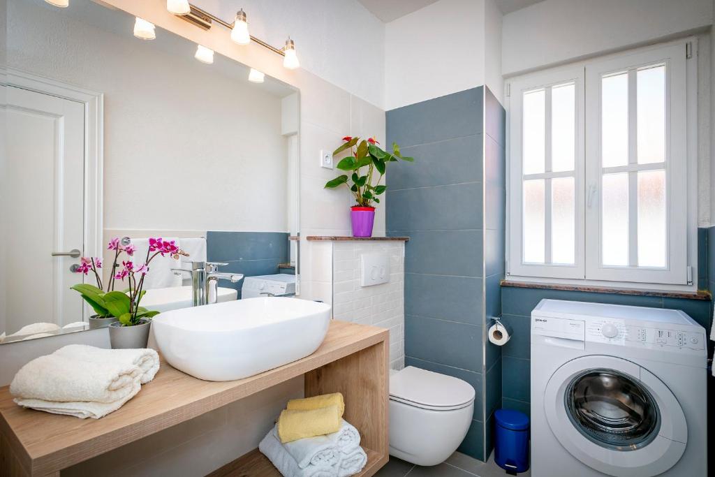 a bathroom with a sink and a washing machine at Villa Riva in Jelsa