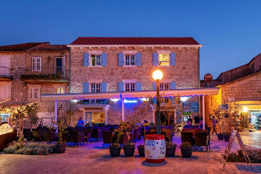 a building with tables and chairs in front of a building at Villa Riva in Jelsa