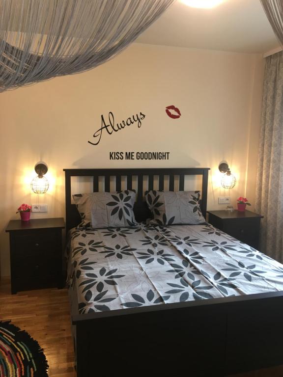 a bedroom with a bed with a sign on the wall at Panorama Apartment Darvenitsa in Sofia