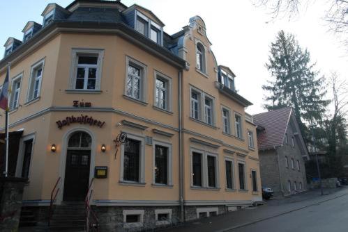 un gran edificio amarillo en el lateral de una calle en Ab ins Postkutscherl, en Würzburg