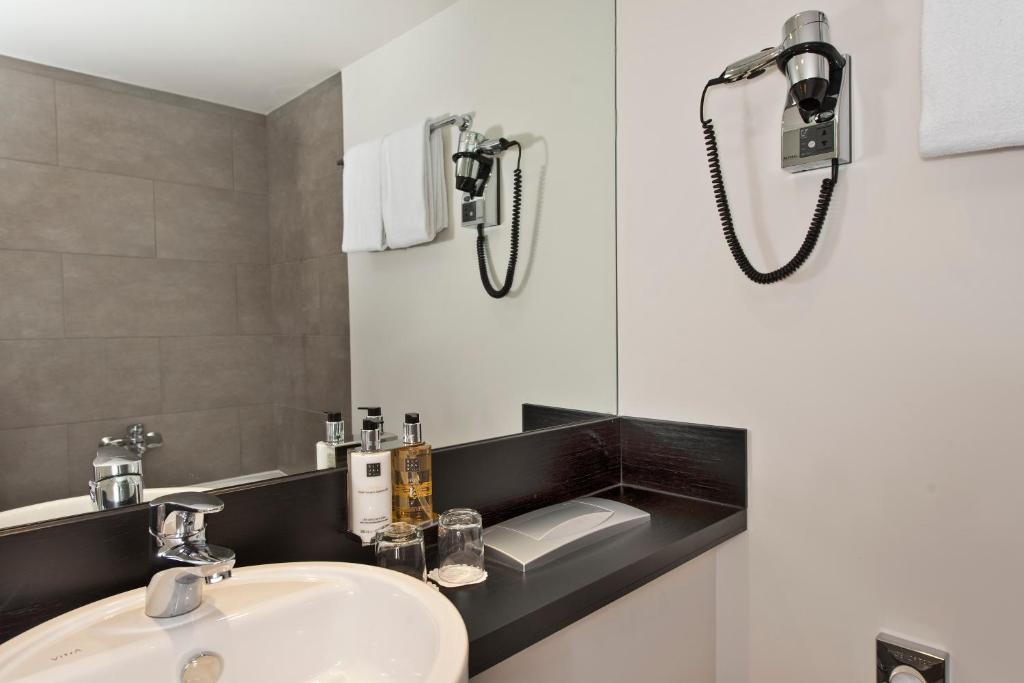 a bathroom with a sink and a mirror at Wyndham Stuttgart Airport Messe in Stuttgart
