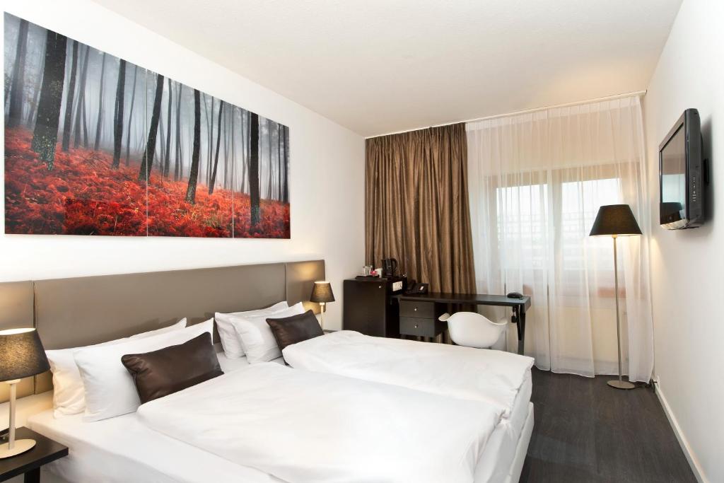 a hotel room with two beds and a painting on the wall at Wyndham Stuttgart Airport Messe in Stuttgart