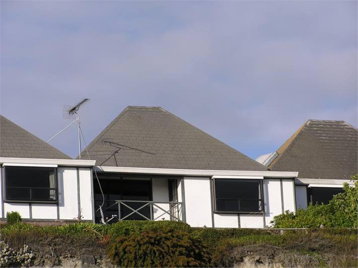 a white house with two pitched roofs at Terrace Apartment in Timaru