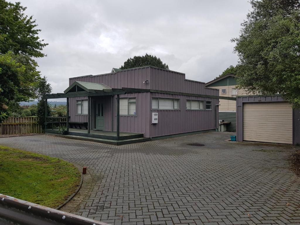 a purple house with a garage and a driveway at Central Taupo Townhouse in Taupo