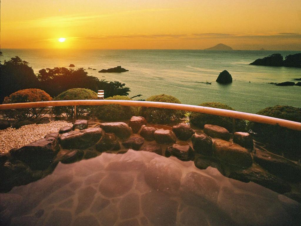 a view of the ocean at sunset from a balcony at Shimoda View Hotel in Shimoda