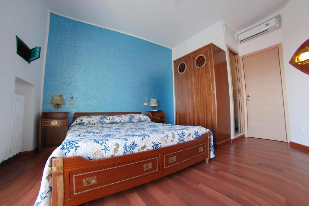 sypialnia z łóżkiem i niebieską ścianą w obiekcie B&B AL MARE w mieście Porto San Giorgio