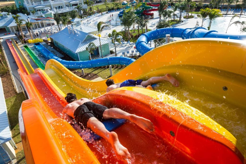 un groupe de personnes sur un toboggan aquatique dans un parc aquatique dans l'établissement Disney Dreams Luxury Home with Private Water Park, à Orlando