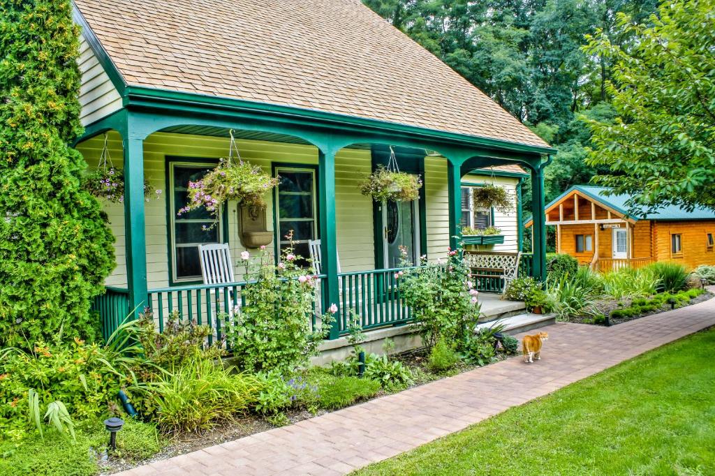 a green house with a dog standing in front of it at Los Gatos Bed & Breakfast in Penn Yan