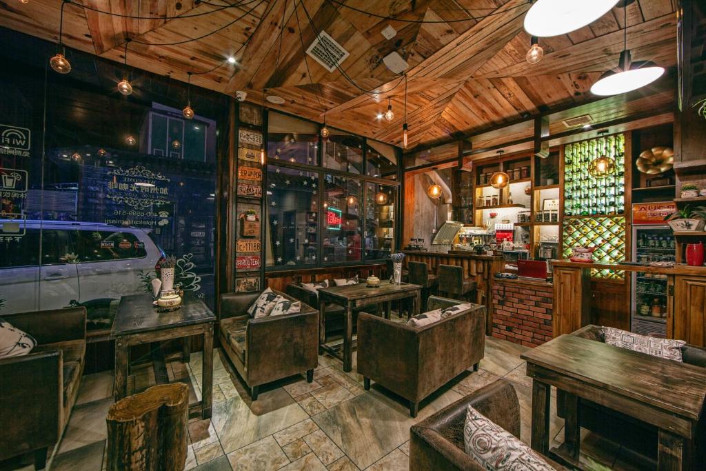 ein Restaurant mit Tischen und Stühlen in einem Zimmer in der Unterkunft Hotel California Zhangjiajie in Zhangjiajie