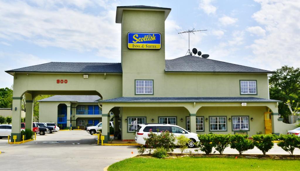 a santa view inn with cars parked in a parking lot at Scottish Inn and Suites Alvin in Alvin