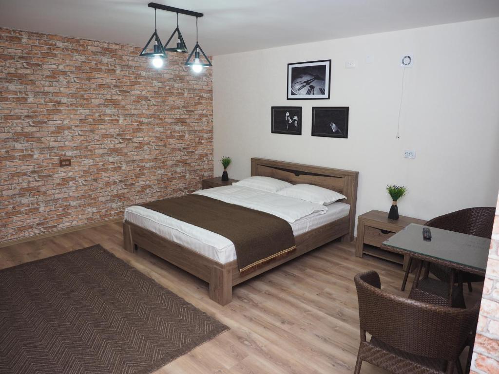 a bedroom with a bed and a brick wall at Prime Time Guest House in Kant