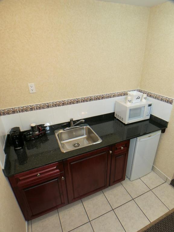 a kitchen counter with a sink and a microwave at Days Inn & Suites by Wyndham Langley in Langley