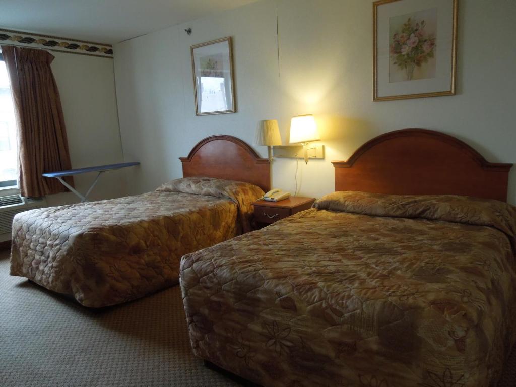 a hotel room with two beds and a table at Red Carpet Inn Brooklyn in Brooklyn