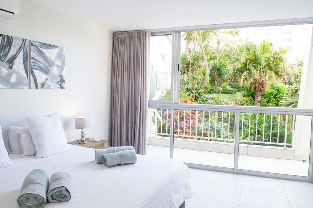 een slaapkamer met een bed en een groot raam bij 14 Kyalanga - by Stay in Umhlanga in Durban