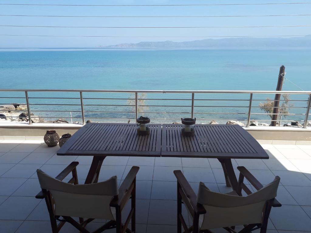 uma mesa e cadeiras numa varanda com vista para o oceano em Vrachati Sea Front House em Káto Ássos