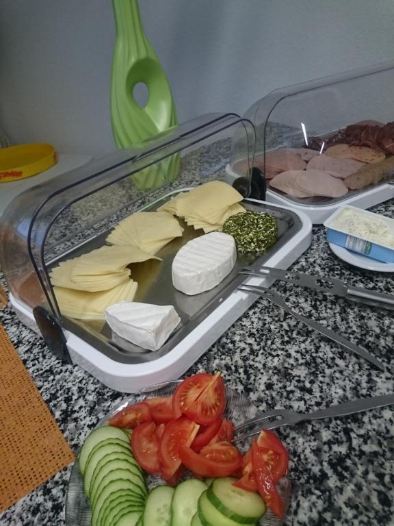 a container of food with tomatoes and cheese on a counter at Hotel Asterra in Saalfeld