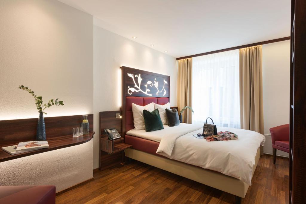 a hotel room with a bed and a window at Hotel Scheuble in Zürich