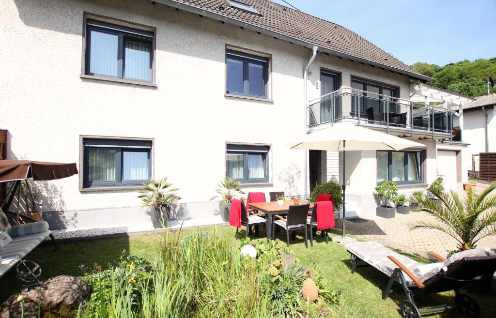 a house with a yard with a table and chairs at Ferienwohnung Brohltal-Aue in Burgbrohl