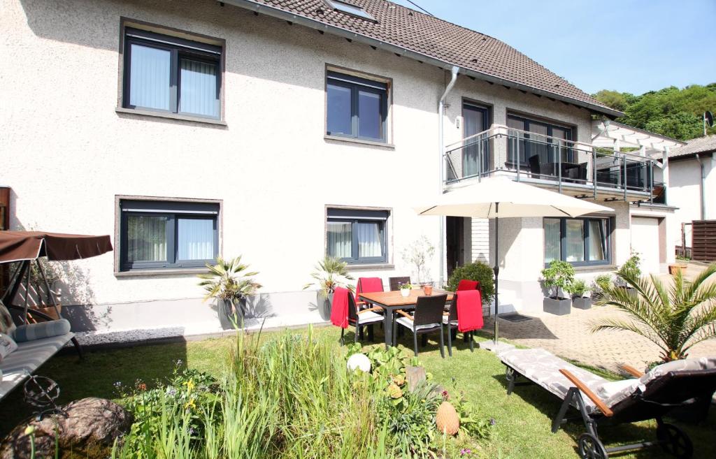 ein Haus mit einem Garten mit einem Tisch und Stühlen in der Unterkunft Ferienwohnung Brohltal-Aue in Burgbrohl