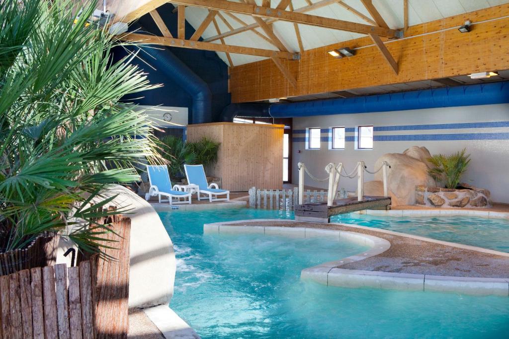 - une grande piscine dans un bâtiment avec piscine dans l'établissement Le Village Cancalais, à Cancale