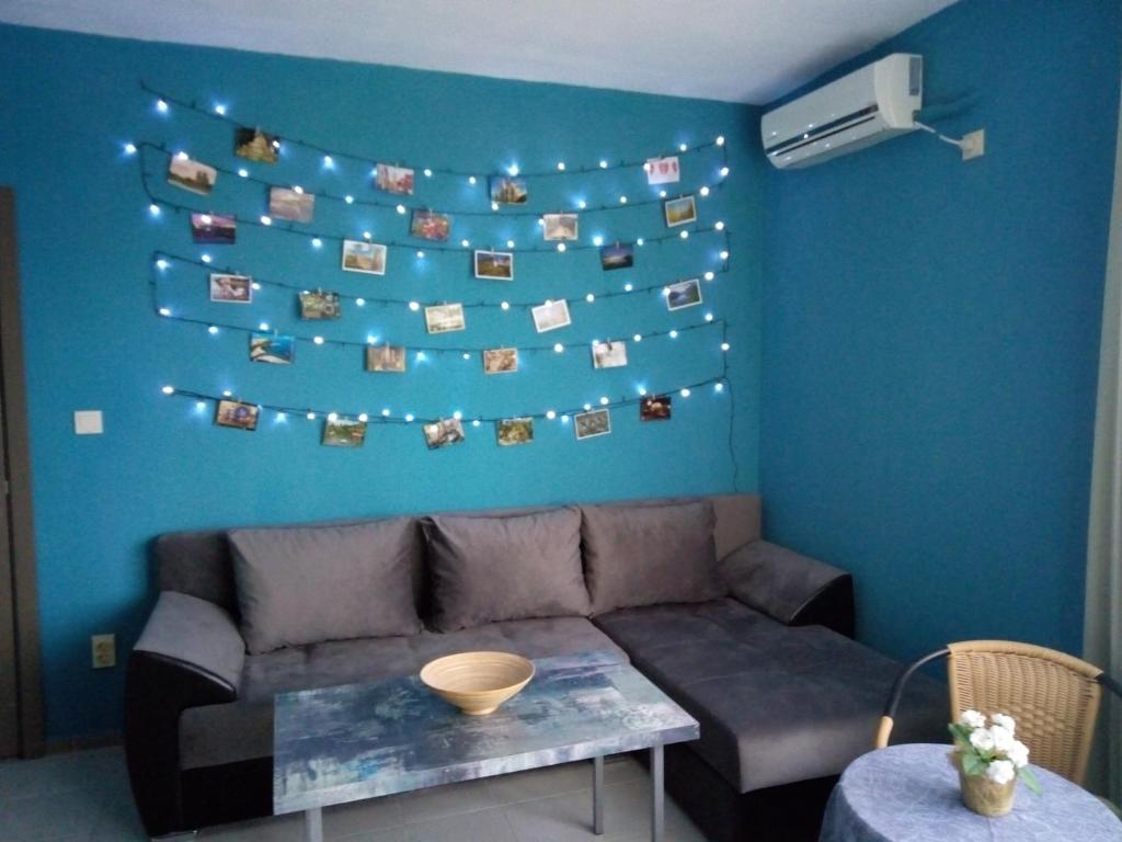 a living room with a couch and a blue wall at Aura in Primorsko