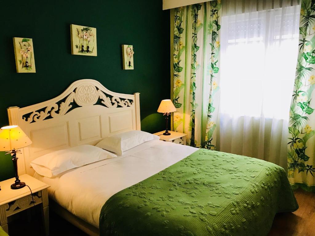 1 dormitorio con cama blanca y pared verde en Hotel Le Festival, en Cannes