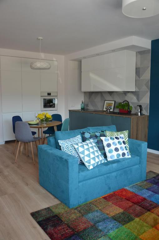 un sofá azul en una sala de estar con cocina en Apartament Pruszków, en Pruszków