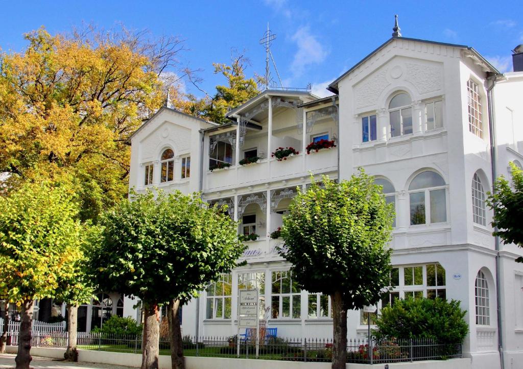 a white building with trees in front of it at Jasmund-04-Ferienwohnung-bis-6-Personen-Wohng-4 in Ostseebad Sellin