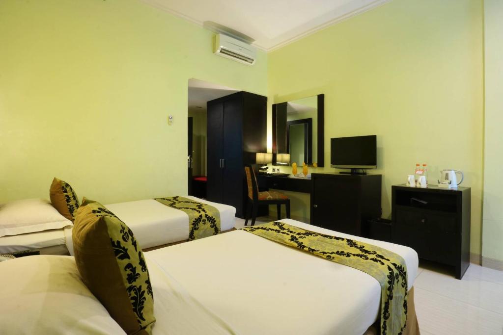Postel nebo postele na pokoji v ubytování Sari Ater Kamboti Hotel Bandung
