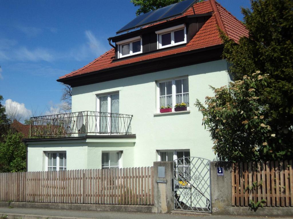 a white house with a red roof and a fence at Ferienhaus Villa Korn in Ebern