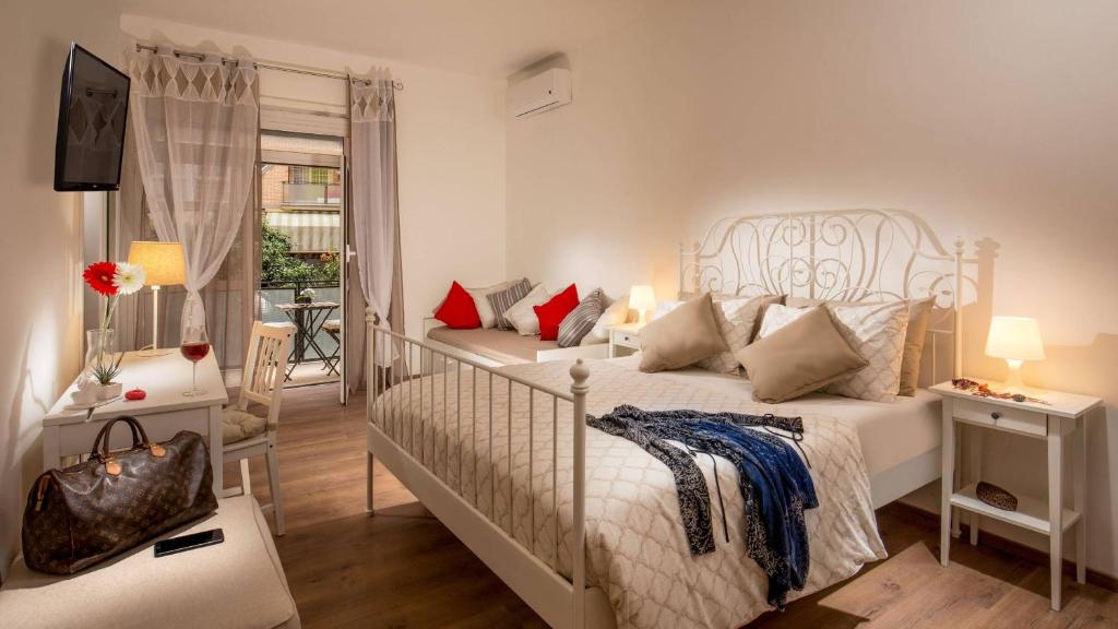 Sweet Rooms Piramide Bed and Breakfast في روما: غرفة نوم بيضاء مع سرير وأريكة