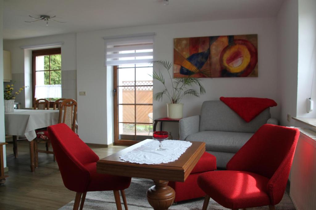 sala de estar con sofá y sillas rojas en Ferienwohnung Kranichnest en Malschwitz