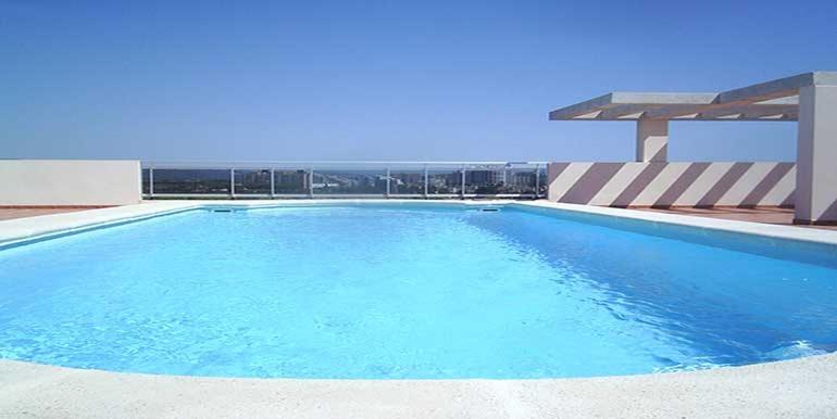 een groot blauw zwembad voor een gebouw bij desolyplaya Acrópolis in Oropesa del Mar