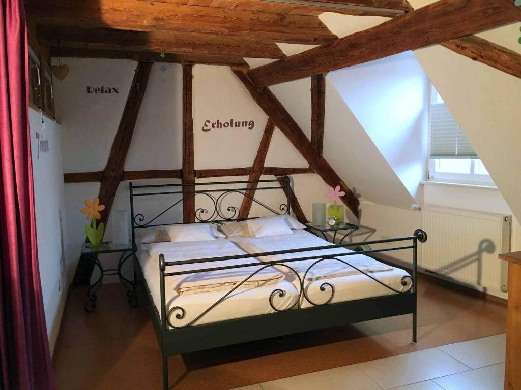 um quarto com uma cama de metal num sótão em Ferienhaus Finster em Volkach