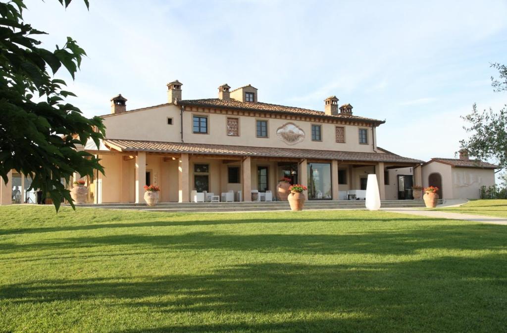 a large house with a large lawn in front of it at Agriturismo Colleoli in Palaia