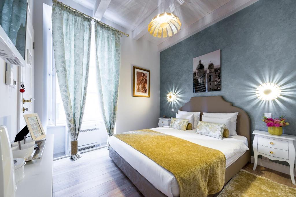 a bedroom with a large bed with a yellow blanket at Dominus Little Palace in Dubrovnik